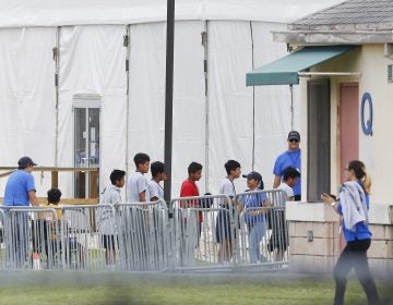 Immigrant children walk in a line outside the Homestead Temporary Shelter for Unaccompanied Children