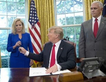 In this June 20, 2018, photo, President Donald Trump gives the pen he used to sign the executive order to end family separations at the border to Homeland Security Secretary Kirstjen Nielsen, (left), as Vice President Mike Pence, (right), watches in the Oval Office of the White House in Washington. Nielsen has one hard-earned presidential signing pen, receiving hers after Trump used it to sign the executive order. By the time Trump reversed his policy Wednesday, Nielsen had been both yelled at and praised by Trump and pilloried for repeating his falsehoods.  (Pablo Martinez Monsivais/AP Photo)