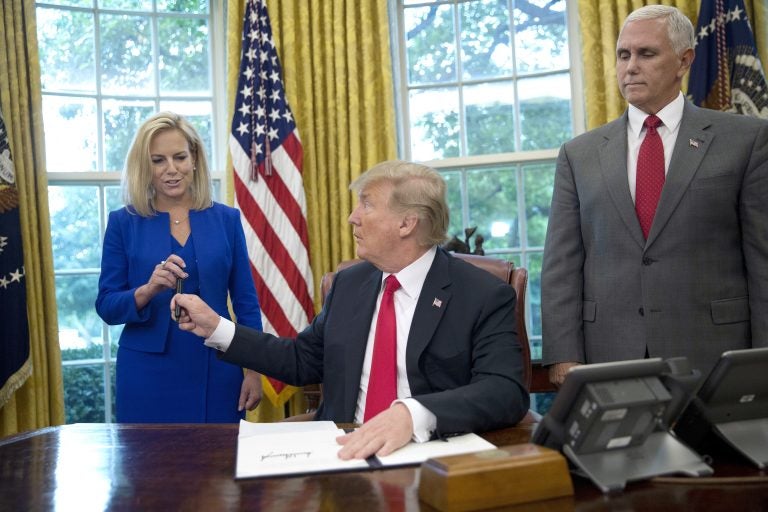 In this June 20, 2018, photo, President Donald Trump gives the pen he used to sign the executive order to end family separations at the border to Homeland Security Secretary Kirstjen Nielsen, (left), as Vice President Mike Pence, (right), watches in the Oval Office of the White House in Washington. Nielsen has one hard-earned presidential signing pen, receiving hers after Trump used it to sign the executive order. By the time Trump reversed his policy Wednesday, Nielsen had been both yelled at and praised by Trump and pilloried for repeating his falsehoods.  (Pablo Martinez Monsivais/AP Photo)