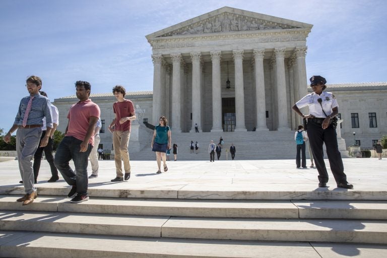 Visitors depart the Supreme Court early Monday, June 25, 2018. The justices upheld the Trump administration's travel ban on Tuesday. (AP Photo/J. Scott Applewhite)