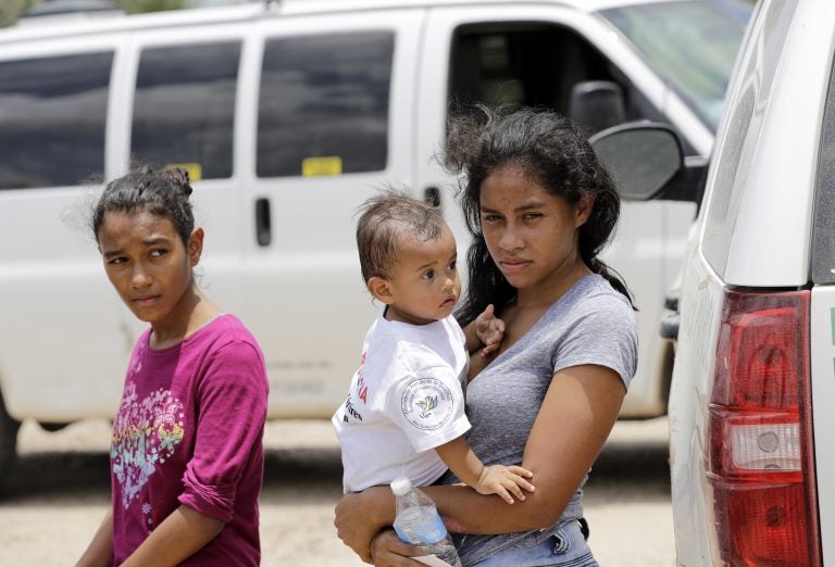 A mother migrating from Honduras holds her 1-year-old child as surrendering to U.S. Border Patrol agents after illegally crossing the border Monday, June 25, 2018, near McAllen, Texas. (AP Photo/David J. Phillip)