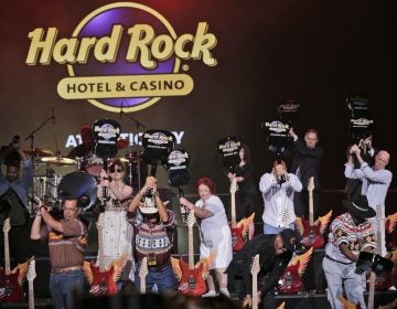 Celebrities and VIPs smash guitars as part of the grand opening celebration at the Hard Rock Hotel and Casino in Atlantic City Thursday. Movie stars lent an air of celebrity glitz to the gritty seaside gambling resort as two of its shuttered casinos reopened with more than 6,000 of the 11,000 jobs it lost during a brutal stretch of casino shutdowns. (Seth Wenig/AP Photo)