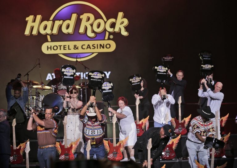 Celebrities and VIPs smash guitars as part of the grand opening celebration at the Hard Rock Hotel and Casino in Atlantic City Thursday. Movie stars lent an air of celebrity glitz to the gritty seaside gambling resort as two of its shuttered casinos reopened with more than 6,000 of the 11,000 jobs it lost during a brutal stretch of casino shutdowns. (Seth Wenig/AP Photo)