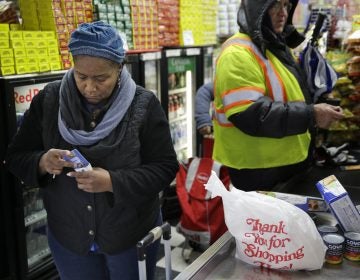 A woman organizes her pocketbook after paying for groceries with an EBT card (Seth Wenig/AP Photo)