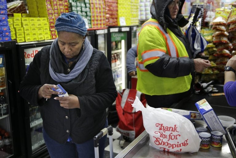 A woman organizes her pocketbook after paying for groceries with an EBT card (Seth Wenig/AP Photo)