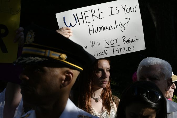 Protester holding a sign during Vice President Mike Pence's visit to Philadelphia. June 19. 2018. (Bastiaan Slabbers for WHYY)