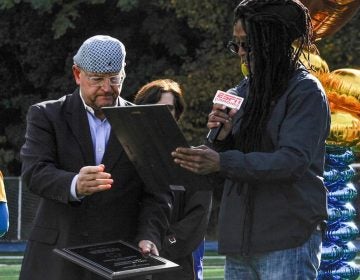 Muzz Skillings alongside Joe Krause, Audible board member, presenting a plaque for Autism Awareness. (Photo Courtesy/Audible for Autism)