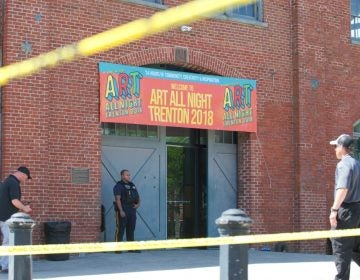 A police officer stands guard outside of the Historic Roebling Wire Works building on S. Clinton Avenue in Trenton, N.J. following a shooting at an all-night arts festival being held there. (Natalie Piserchio for WHYY) 