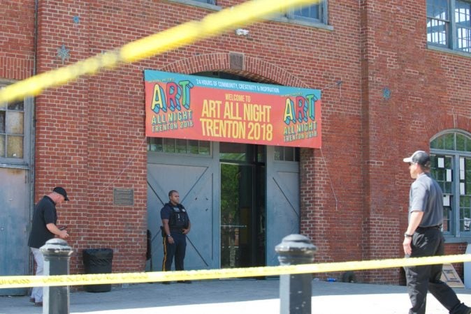 A police officer stands guard outside of the Historic Roebling Wire Works building on S. Clinton Avenue in Trenton, N.J. following a shooting at an all-night arts festival being held there. (Natalie Piserchio for WHYY) 