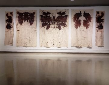 Russell Craig's wall-sized paintings resemble Rorschach tests, with the faces of women killed by police peering out from inside the abstract shapes. His work is on display in a group show at the African American Museum in Philadelphia. (Image courtesy of the African American Museum in Philadelphia)