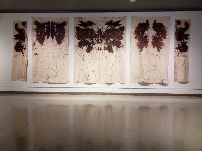 Russell Craig's wall-sized paintings resemble Rorschach tests, with the faces of women killed by police peering out from inside the abstract shapes. His work is on display in a group show at the African American Museum in Philadelphia. (Image courtesy of the African American Museum in Philadelphia)