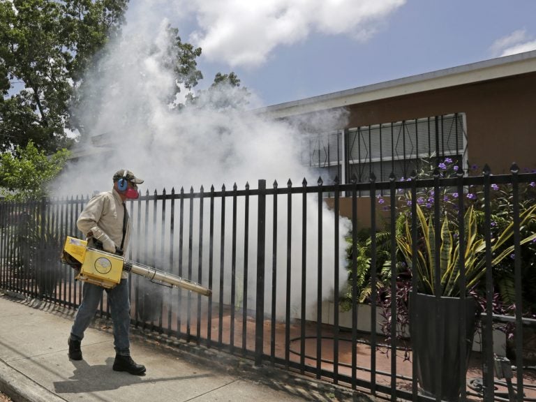 A Miami-Dade County mosquito control worker sprays around a home in August 2016 in the Wynwood area of Miami. A University of Florida study recently identified the first known human case of the mosquito-borne Keystone virus. (Alan Diaz/AP)