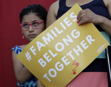 A girl stands with her mother during a Rally For Our Children event to protest a new 