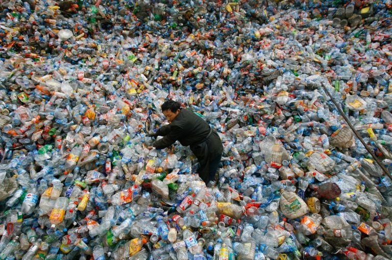 A worker sorts plastic bottles at a recycling center in China. (Jie Zhao/Corbis via Getty Images)
