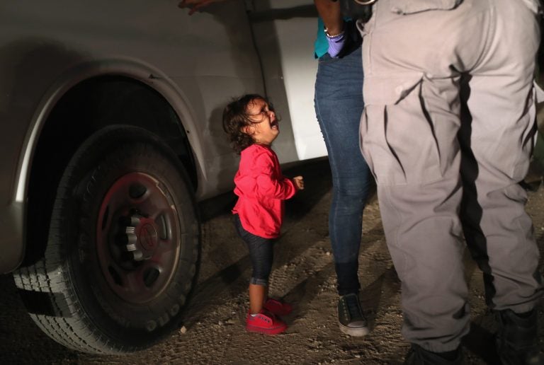 A 2-year-old Honduran asylum seeker cries as her mother is searched and detained near the U.S.-Mexico border on June 12 in McAllen, Texas. The asylum seekers had rafted across the Rio Grande River from Mexico and were detained by U.S. Border Patrol agents before being sent to a processing center for possible separation. (John Moore/Getty images)