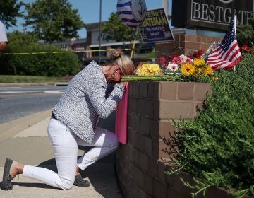 Lynne Griffin pays her respects at a makeshift memorial outside the Capital Gazette offices, one day after a gunman killed five people in its newsroom. Griffin was a journalism student under John McNamara — one of the people killed Thursday. (Mark Wilson/Getty Images)