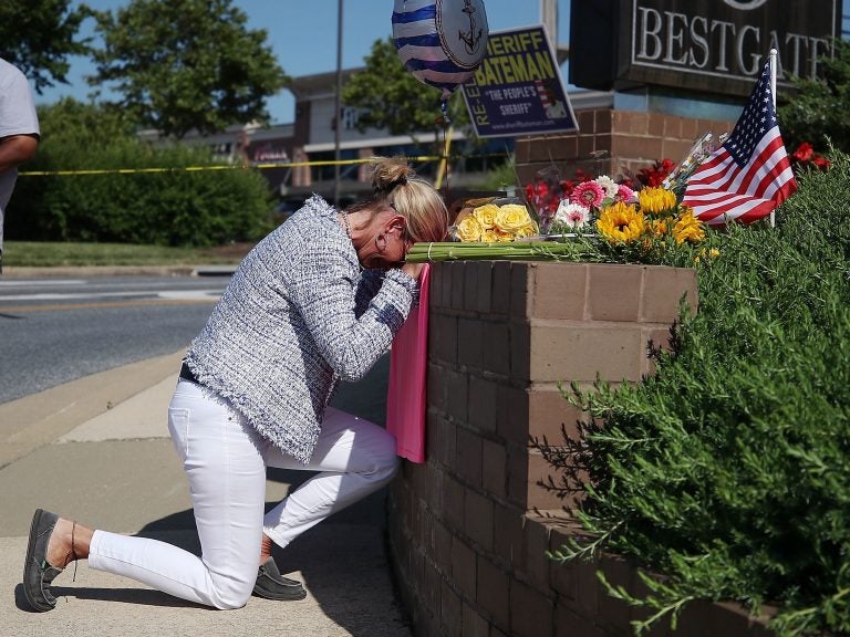 Lynne Griffin pays her respects at a makeshift memorial outside the Capital Gazette offices, one day after a gunman killed five people in its newsroom. Griffin was a journalism student under John McNamara — one of the people killed Thursday. (Mark Wilson/Getty Images)