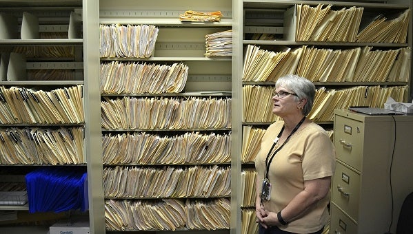 Environmental risk inspector Marilou Yingling stands in front of years worth of files related to lead found in York homes. (Brett Sholtis/Transforming Health)