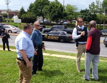 Police officers talk to a man as they respond to a shooting at the Capital Gazette newspaper in Annapolis, Md., on Thursday. (Greg Savoy/Reuters)