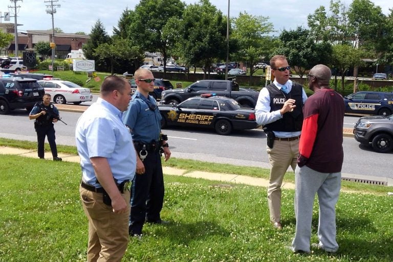 Police officers talk to a man as they respond to a shooting at the Capital Gazette newspaper in Annapolis, Md., on Thursday. (Greg Savoy/Reuters)