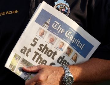 Staff of The Capital put out a newspaper on Friday, one day after a gunman killed five people in its offices at the Capital Gazette. Here, Steve Schuh, county executive of Anne Arundel County, Md., holds a copy of Friday's paper. (Joshua Roberts/Reuters)