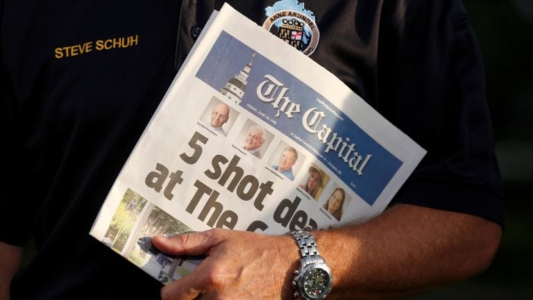 Staff of The Capital put out a newspaper on Friday, one day after a gunman killed five people in its offices at the Capital Gazette. Here, Steve Schuh, county executive of Anne Arundel County, Md., holds a copy of Friday's paper. (Joshua Roberts/Reuters)