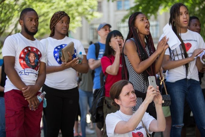 Maureen Boland, a 9th grade English teacher at Parkway, (center) videos her students as they give impassioned speeches to a crowd gathered at City Hall for a rally and march in support of gun reform. At Parkway Center City Middle College, 56% of the student body has witnessed a shooting. (Emily Cohen for WHYY)