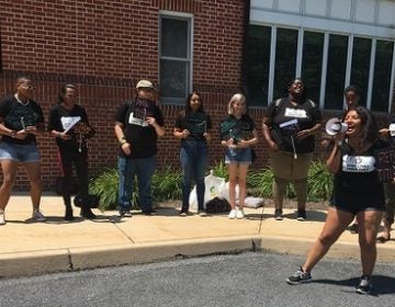 Outside the board of governors meeting, a small group of students rallied for, among other things, free higher education. (Katie Meyer/WITF)