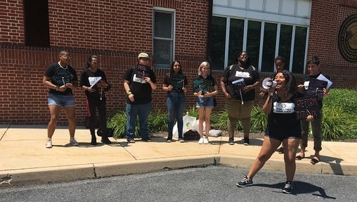 Outside the board of governors meeting, a small group of students rallied for, among other things, free higher education. (Katie Meyer/WITF)