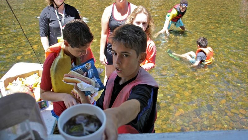 Joey Roth grabs a hot dog and a soda at the Famous River Hot Dog Man. (Emma Lee/WHYY)