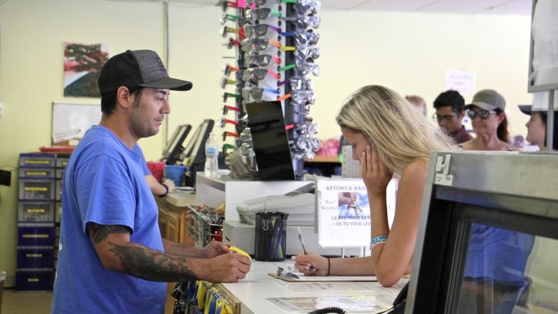 Mathew Crance checks in customers at Delaware River Tubing in Milford. Leaving the office with little more than a life jacket and a bottle of sunscreen, the tubers will be picked up down river four to six hours later. (Emma Lee/WHYY)