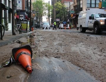 Silt and debris fill Center City streets around the site of a massive water main break. (Emma Lee/WHYY)