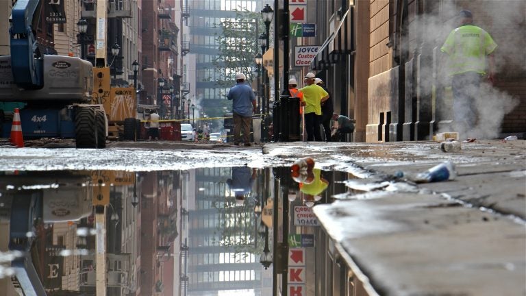Steam pours from vents on Sansom Street near the site of a water main break that flooded Center City streets. (Emma Lee/WHYY)