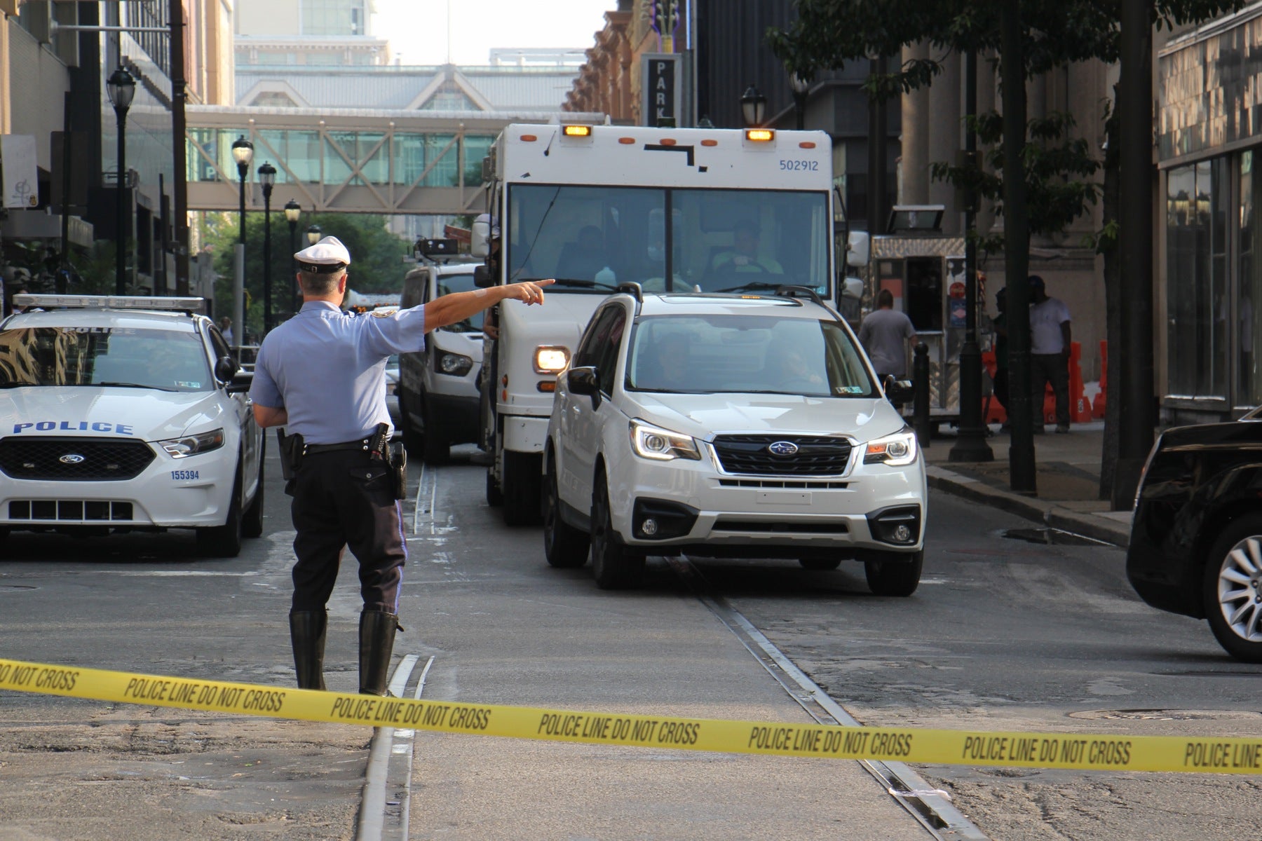 A police officer diverts traffic at 12th and Chestnut streets around the water main break that closed roads around Chestnut and Walnut streets during rush hour.