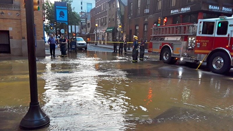 The intersection at 10th and Walnut streets is flooded after a water main break. (Trenae Nuri/WHYY)