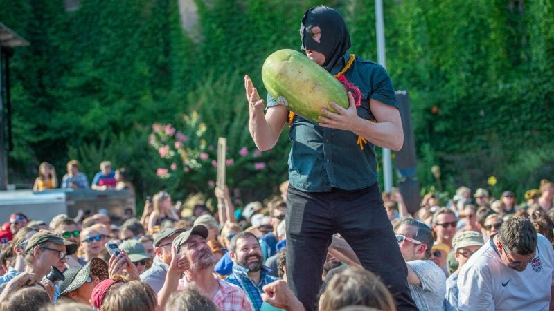 Executioner, played by Sean Kelley, psychs up the crowd before slicing watermelons with the guillotine. (Jonathan Wilson for WHYY)