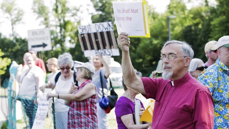 Retired Rev. David W. Brown holds a sign which reads 