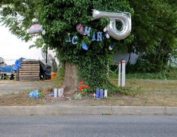 Candles, balloons  and plastic flowers mark the spot where an unarmed man was shot dead by police in Vineland, New Jersey. (Emma Lee/WHYY)