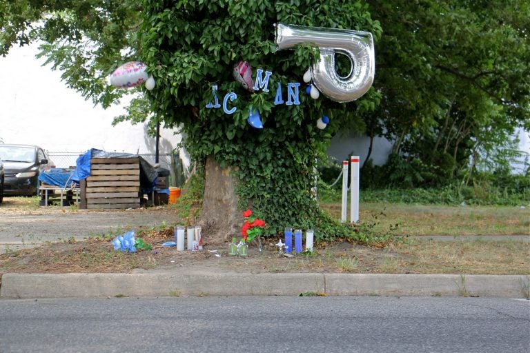 Candles, balloons  and plastic flowers mark the spot where an unarmed man was shot dead by police in Vineland, New Jersey. (Emma Lee/WHYY)