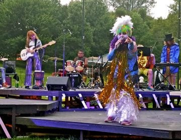 Jess Conda, as Feste, fronts the band Midsummer Madness in a glam rock version of 