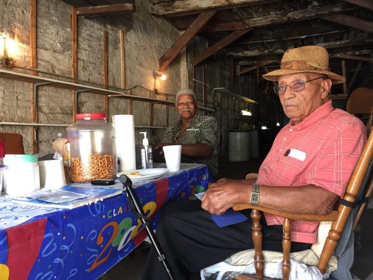 Bufus Outlaw, 93, (right) and Theodore Jackson, 83, hang out in Outlaw's garage in Gray's Ferry. Although they weren't alive for the 1918 riots, they have seen the results ripple through their neighborhood to the present.