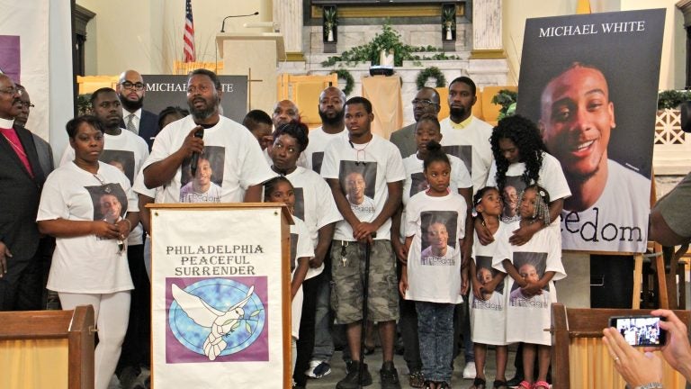 Family members of Michael White, 20, charged in the stabbing death of Sean Schellenger, 37, assemble in the front of True Gospel Tabernacle in South Philadelphia. (Emma Lee/WHYY)