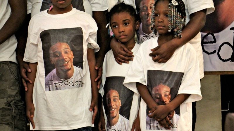 Relatives of Michael White, wearing T-shirts decorated with his photo, participate in a prayer vigil at True Gospel Tabernacle Family Church in South Philadelphia. White is charged in the stabbing death of Sean Schellenger. (Emma Lee/WHYY)