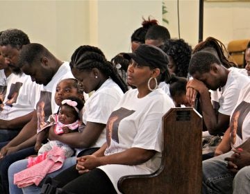 Family members of Michael White, 20, charged in the stabbing death of Sean Shellenger, 37, pray during a vigil at True Gospel Tabernacle in South Philadelphia.