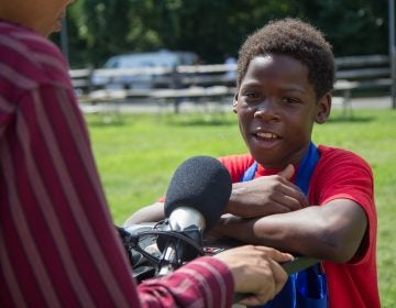 Eryn Greenwood, 10, from Eastwick, shares an experience he had with gun violence at the WURD event at Bartram’s Garden. (Kimberly Paynter/WHYY)