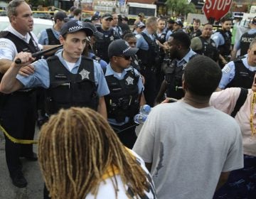 Members of the Chicago Police Department interact with an angry crowd at the scene of a police involved shooting in Chicago, on July 14. (Nuccio DiNuzzo/Chicago Tribune via AP)