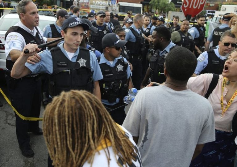 Members of the Chicago Police Department interact with an angry crowd at the scene of a police involved shooting in Chicago, on July 14. (Nuccio DiNuzzo/Chicago Tribune via AP)