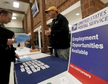 In this Thursday, Nov. 2, 2017, photo, a recruiter from the postal service, right, speaks with an attendee of a job fair in Cheswick, Pa. (AP Photo/Keith Srakocic)