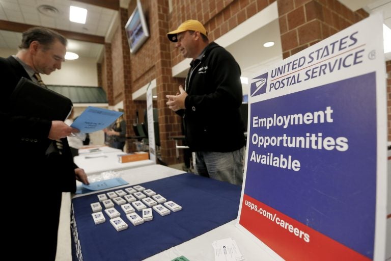 In this Thursday, Nov. 2, 2017, photo, a recruiter from the postal service, right, speaks with an attendee of a job fair in Cheswick, Pa. (AP Photo/Keith Srakocic)