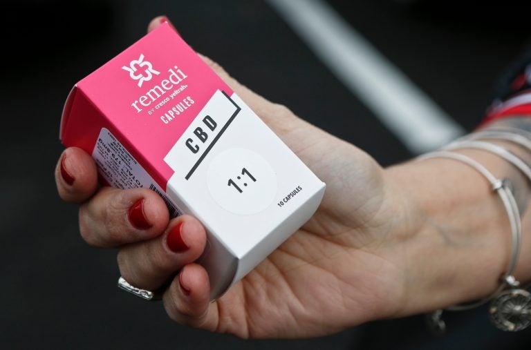 In this Thursday, Feb. 15, 2018 file photo, a woman holds the prescribed medical marijuana product used to treat her daughter's epilepsy after making a purchase at a medical marijuana dispensary in Butler, Pa. Two new studies released on Monday, April 2, 2018 suggest that legalization of marijuana may reduce the prescribing of opioids. (AP Photo/Keith Srakocic)